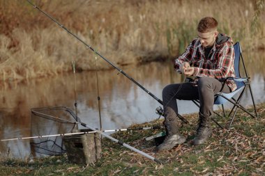 Sabahları nehir kenarında yakışıklı bir adam balık tutuyor.