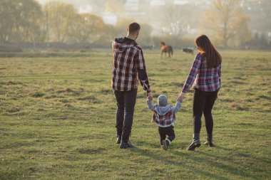 Gün batımı parkında yürüyen sevimli bir aile.