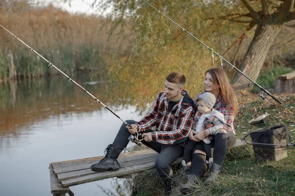 Família sentado perto do rio em uma manhã de pesca — Fotografia de Stock