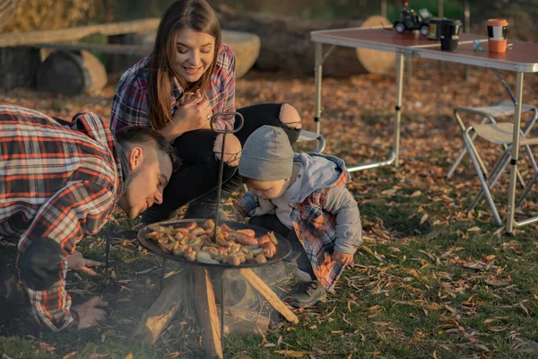 Linda familia sentada en un picnic en un bosque —  Fotos de Stock