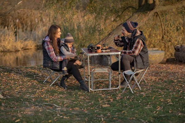 Мила сім'я сидить на пікніку в лісі — стокове фото