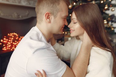 Noel ağacının yanında oturan zarif bir çift.