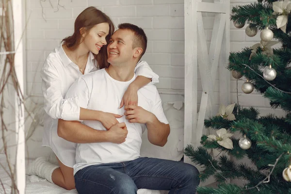 Élégant couple assis sur un lit près de l'arbre de Noël — Photo