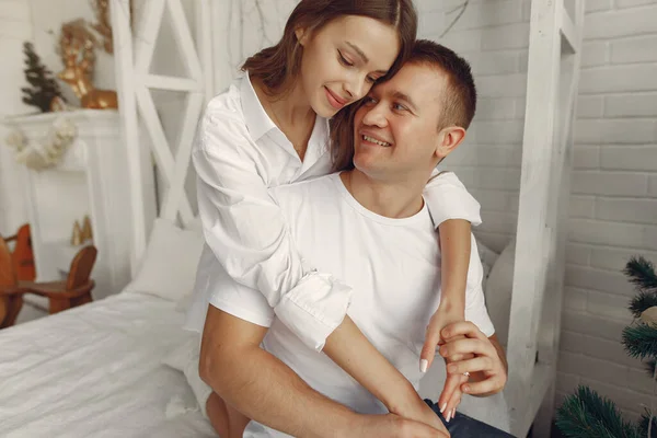 Élégant couple assis sur un lit près de l'arbre de Noël — Photo