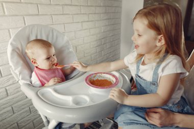 Anne küçük bebeği mutfakta besliyor.