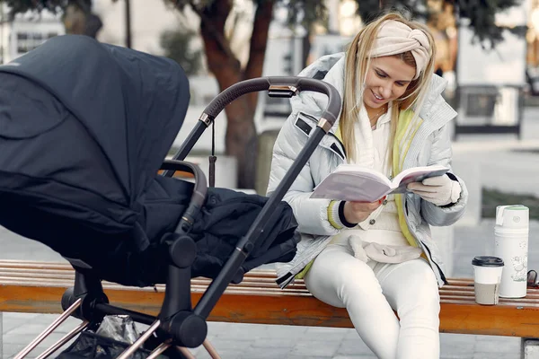 Snygg kvinna som sitter i en stad med vagn — Stockfoto