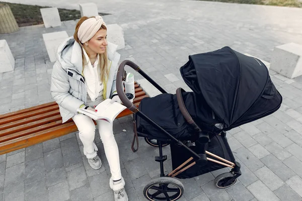 Donna elegante seduta in una città con carrozza — Foto Stock