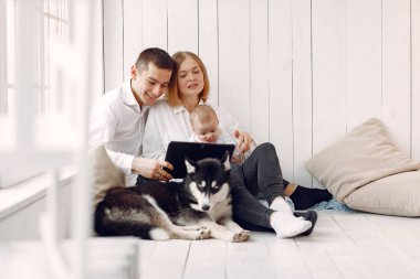 Güzel bir aile yatak odasında bir tabletle vakit geçirir.