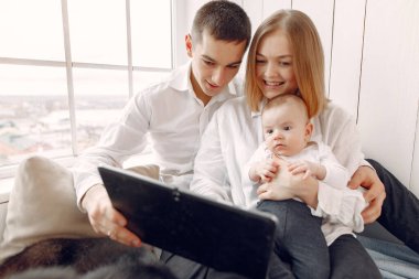 Güzel bir aile yatak odasında bir tabletle vakit geçirir.