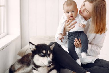 Anne ve küçük oğlu evde köpekle oynuyorlar.