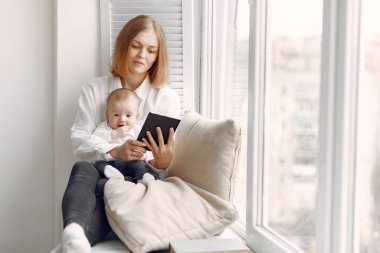 Anne ve küçük oğlu pencere eşiğinde oturuyor.