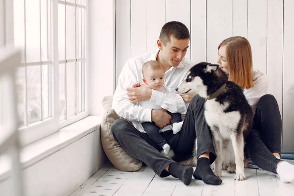 Hermosa familia pasar tiempo en un dormitorio con un perro — Foto de Stock