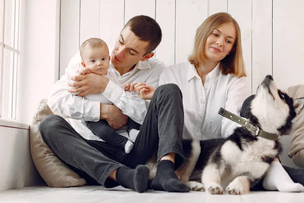 Hermosa familia pasar tiempo en un dormitorio con un perro — Foto de Stock