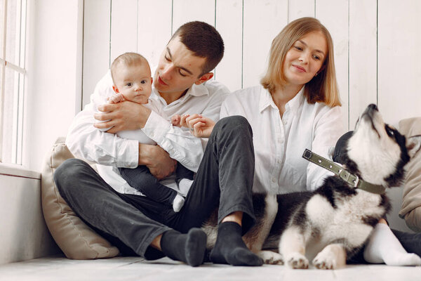 Beautiful family spend time in a bedroom with a dog