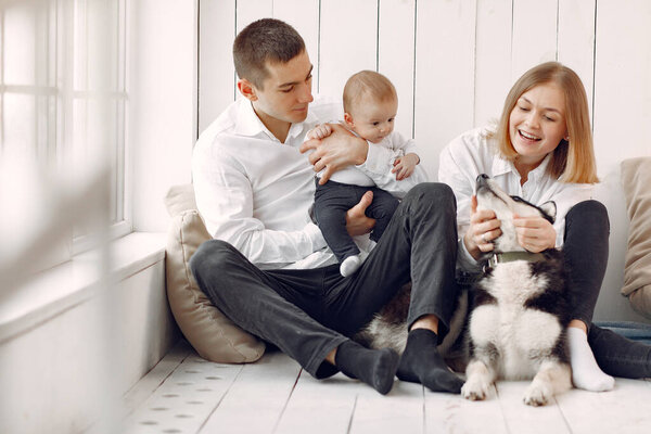 Beautiful family spend time in a bedroom with a dog