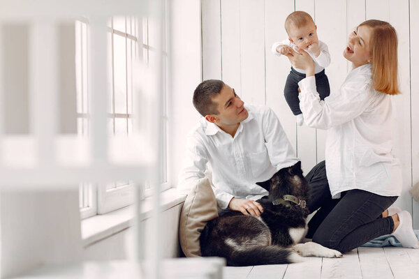 Beautiful family spend time in a bedroom with a dog