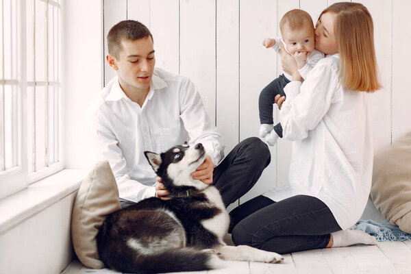 Beautiful family spend time in a bedroom with a dog