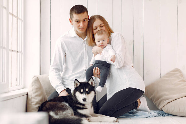 Beautiful family spend time in a bedroom with a dog