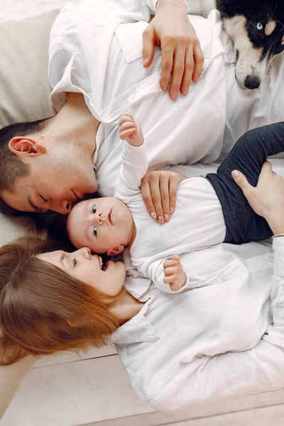 Hermosa familia pasar tiempo en un dormitorio con un perro — Foto de Stock