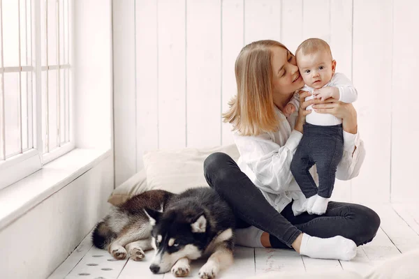 Madre e hijo pequeño jugando con el perro en casa — Foto de Stock