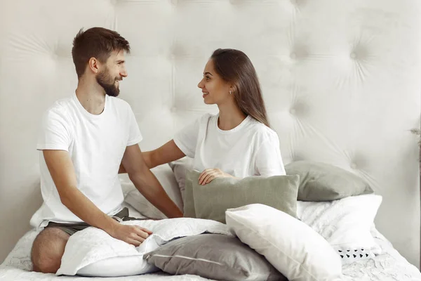 Пара, сидящая на кровати в комнате — стоковое фото