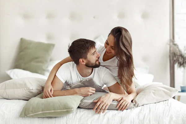 Couple sitting on a bed in a room — Stock Photo, Image