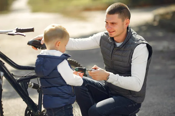 Padre con hijo repare la moto en un parque —  Fotos de Stock