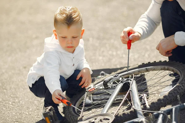 Father with son repare the bike in a park — Stock Photo, Image