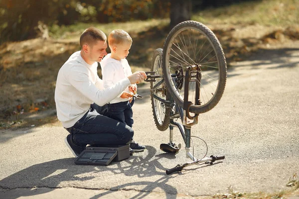 Father with son repare the bike in a park — Stock Photo, Image