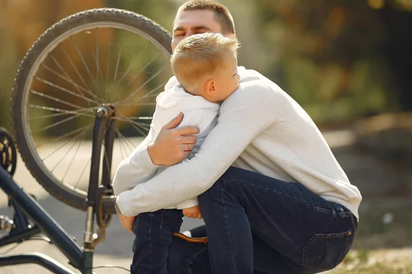 父亲和儿子在公园里修理自行车 — 图库照片