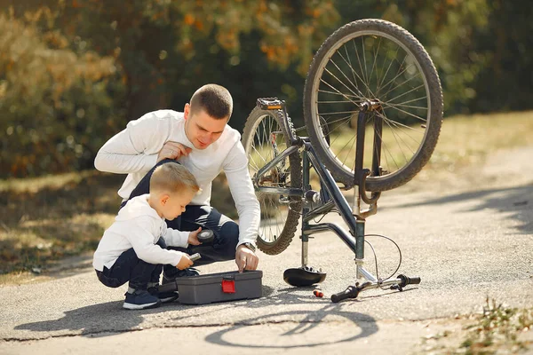 Padre con hijo repare la moto en un parque —  Fotos de Stock