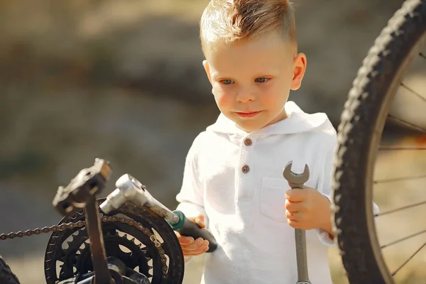 Little boy repair his bike in a park — Stock Photo, Image