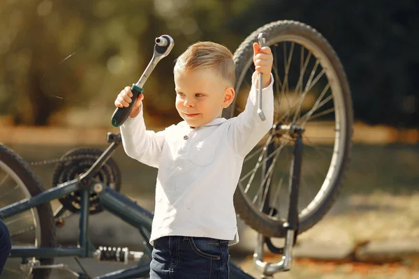 Little boy repair his bike in a park — Stock Photo, Image