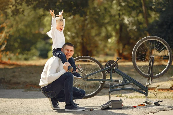 Padre con figlio prepara la bici in un parco — Foto Stock