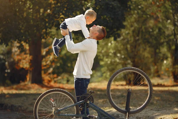 Oğlu olan baba parktaki bisikleti tamir ediyor. — Stok fotoğraf