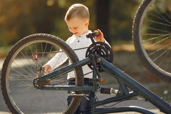 Pequeño niño reparar su bicicleta en un parque —  Fotos de Stock