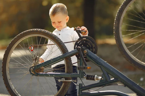 Little boy repair his bike in a park — Stock Photo, Image