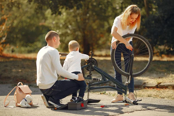 Famiglia con figlio prepara la bici in un parco — Foto Stock