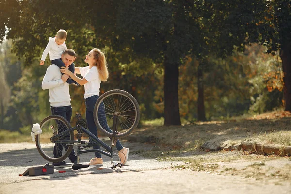 बेटे के साथ परिवार एक पार्क में बाइक मरम्मत करता है — स्टॉक फ़ोटो, इमेज