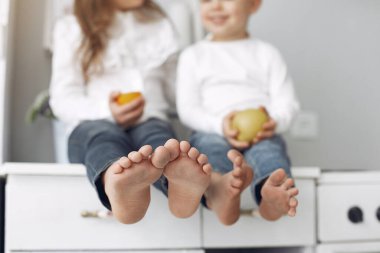 Çocuklar evde bir mutfakta oturuyor.