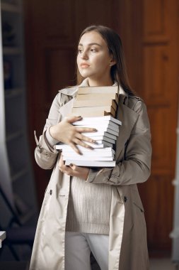 Öğrenci kütüphanede kitap arıyor.