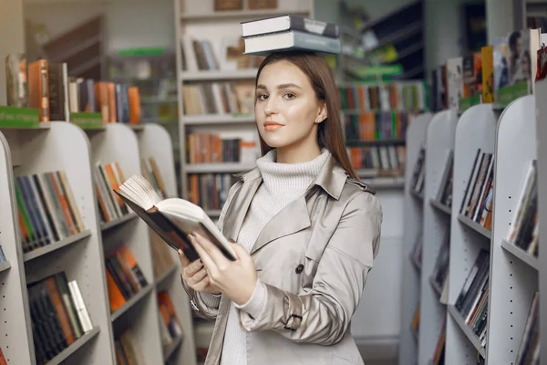 Estudiante buscando un libro en la biblioteca —  Fotos de Stock