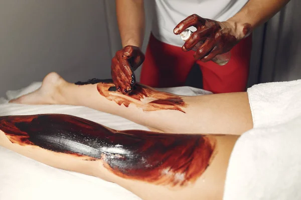 O doutor massageia a mulher com um chocolate — Fotografia de Stock