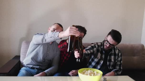 Tři kamarádi v tričkách, co spolu pijou pivo. — Stock video