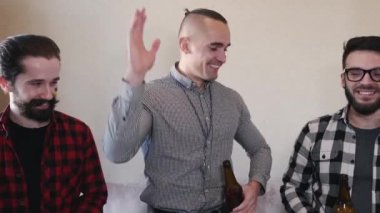 Futbol maçı izleyen ve bira içen üç arkadaş.