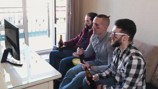 Män med ukrainska flaggor sitter på soffan titta på fotboll — Stockvideo
