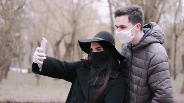 Jovem e um menino estão tirando fotos um do outro em um parque — Vídeo de Stock