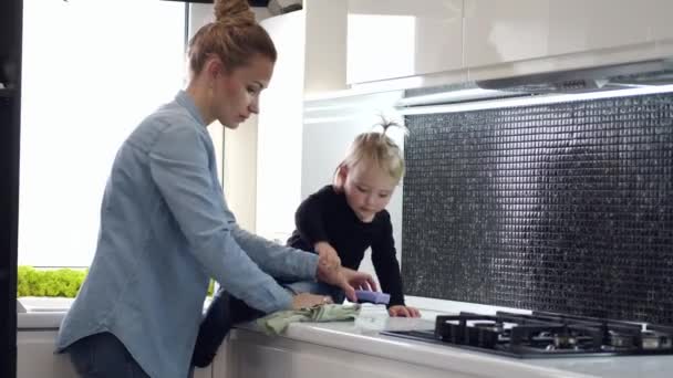Vrouw en klein meisje schoonmaken keuken met behulp van washandje — Stockvideo