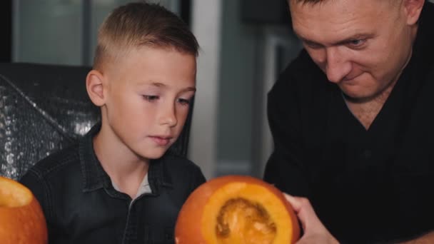 Baba oğluna cadılar bayramı için balkabağı oymayı öğretiyor. — Stok video