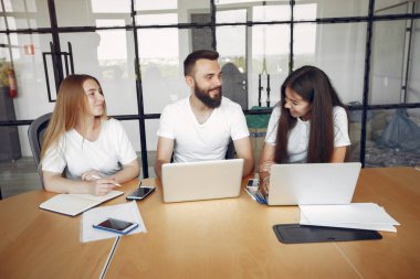 Genç ekip birlikte çalışıyor ve bilgisayarı kullanıyor.